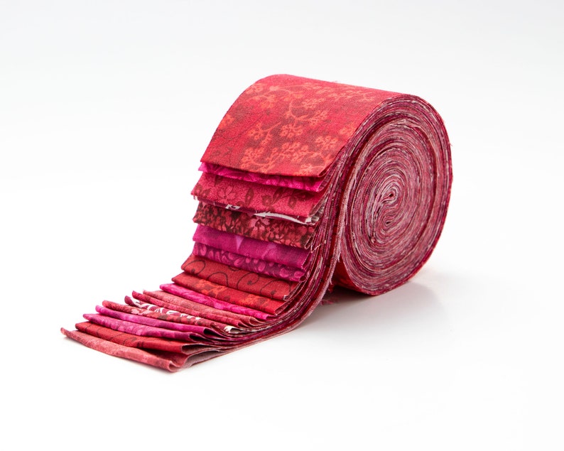 May include: A roll of red and pink fabric with floral patterns. The fabric is rolled up and tied with a ribbon.