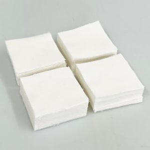 May include: Four square stacks of white fabric pieces arranged in a grid. Each stack consists of multiple layers of plain, opaque white material with visible raw edges, neatly aligned to form uniform, compact, and clean-cut square shapes.