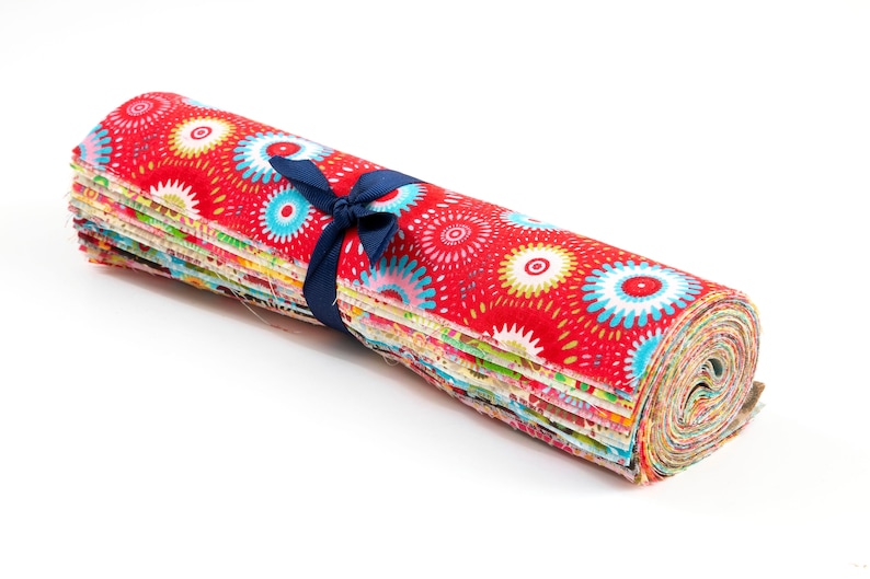 May include: A roll of colorful fabric scraps tied with a blue ribbon. The fabric features a red background with white and blue circular patterns.