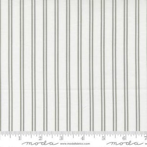 May include: White fabric with vertical gray stripes. The stripes are evenly spaced and run the length of the fabric. A ruler is at the bottom of the fabric, with the word "moda" printed on it.