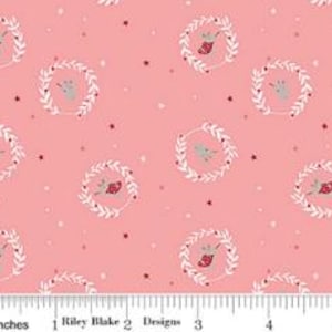 May include: A pink fabric featuring a repeating pattern of white wreaths, each enclosing a small gray animal wearing a red scarf or a red stocking. The design is accented with tiny white dots and small red stars. A ruler is visible at the bottom edge.