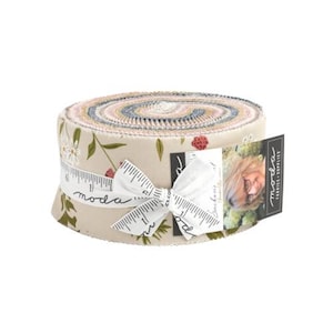 May include: A roll of fabric featuring a floral print in shades of pink, green, and blue. The fabric is wrapped around a cardboard tube and tied with a white ribbon. The label reads "moda fabrics -  simply stylish".