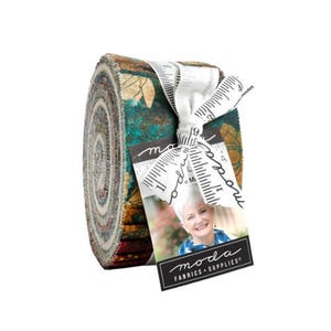 May include: A jelly roll of fabric strips featuring a dark teal and gold floral pattern. The roll is tied with a white ribbon printed with a black measuring tape design and a tag featuring a portrait of a person and the text moda FABRICS + SUPPLIES.