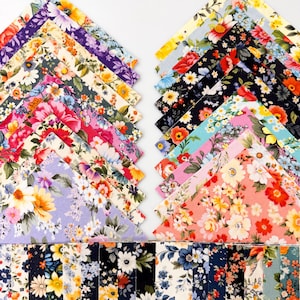 May include: A collection of square fabric swatches featuring diverse floral patterns in vibrant colors including red, yellow, blue, purple, and pink. The swatches are arranged in two diagonal stacks and a horizontal row, displaying various botanical prints.