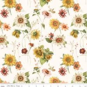 May include: A fabric with a repeating floral pattern featuring sunflowers, orange and red flowers, and green leaves on a cream background. The sunflowers are yellow and have brown centers. A ruler is at the bottom.