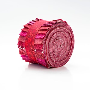 May include: A roll of red and pink fabric with a floral pattern. The fabric is rolled up and tied with a red ribbon.