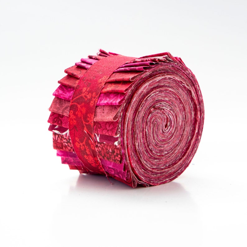 May include: A roll of red and pink fabric with a floral pattern. The fabric is rolled up and tied with a red ribbon.