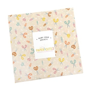 May include: A square fabric piece with a cream background, covered in colorful scissors and staple designs. The fabric has a white label with the text "RUBY STAR SOCIETY" and "PAPER CUTS 2".