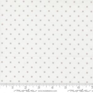 May include: White fabric with a repeating pattern of small, evenly spaced gray squares. The fabric has a ruler along the bottom edge, marked in inches, with the word "moda" printed on it.