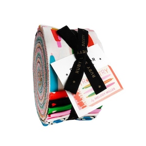 May include: A rolled bundle of colorful fabric strips, featuring a variety of patterns and colors. The bundle is secured with a black ribbon and a tag that reads "Ruby Star Society" and "By Melody Miller". The fabric appears to be cotton, suitable for quilting or crafting.