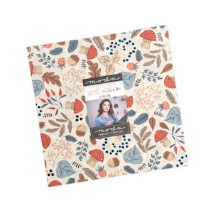 May include: A square stack of fabric squares featuring a cream background with a repeating pattern of red mushrooms, brown acorns, blue leaves, and dark blue berries. A central label reads Moda Nature's Sketchbook by Janet Clare and Moda Fabrics.