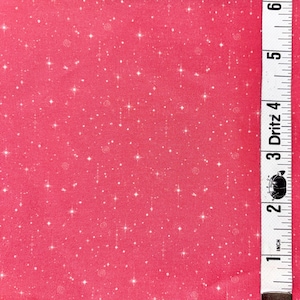 May include: A vibrant pink fabric featuring a repeating pattern of small white stars and circular swirls. A white measuring tape is positioned vertically along the right edge, showing a length of approximately 6 inches for the visible section.