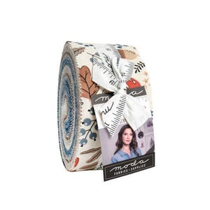 May include: A jelly roll of fabric strips featuring a cream background with a pattern of brown oak leaves, blue berries, and acorns. The roll is tied with a white ribbon printed with a ruler design and a tag featuring a person and the text Moda Fabrics.