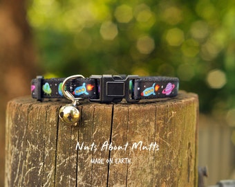 Peut inclure: Collier noir pour chat avec un motif spatial de fusées, planètes et étoiles. Il est doté d'une boucle en plastique et d'une clochette argentée. Le texte "Nuts About Mutts" et "MADE ON EARTH" est imprimé sur le bois.