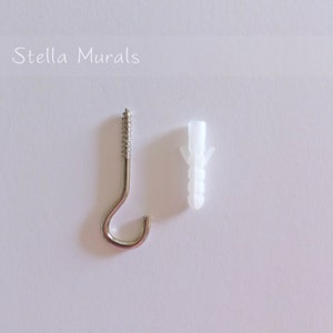 May include: A silver hook with a screw and a white plastic anchor. The hook is designed for hanging items on a wall.