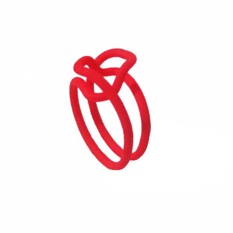 Puede incluir: Un anillo rojo hecho de dos bandas entrelazadas.