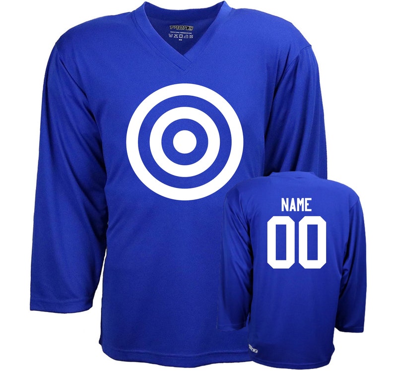 Puede incluir: Una camiseta de hockey azul real con un dise&ntilde;o de diana blanca en la parte delantera y el texto "NAME 00" en la parte posterior.