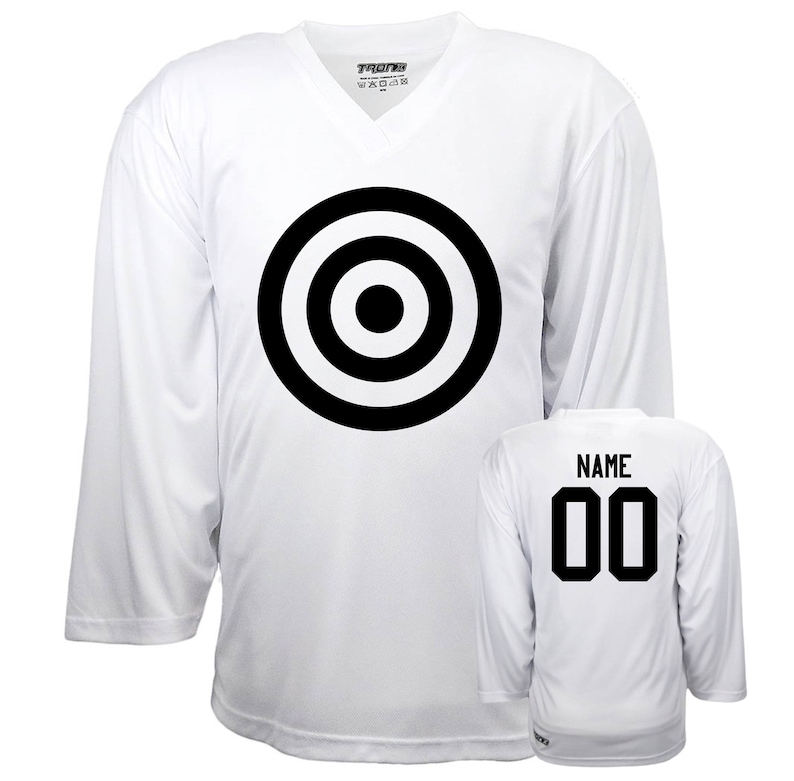 Puede incluir: Camiseta de hockey blanca con un dise&ntilde;o de diana en blanco y negro en la parte delantera y el n&uacute;mero 00 en la parte posterior. La camiseta tiene un cuello en V y mangas largas.