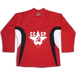 Puede incluir: Camiseta roja de manga larga con detalles en blanco y negro. La camiseta presenta una estrella blanca con un martillo y una hoz rojos en su interior y el texto "CCCP" encima.