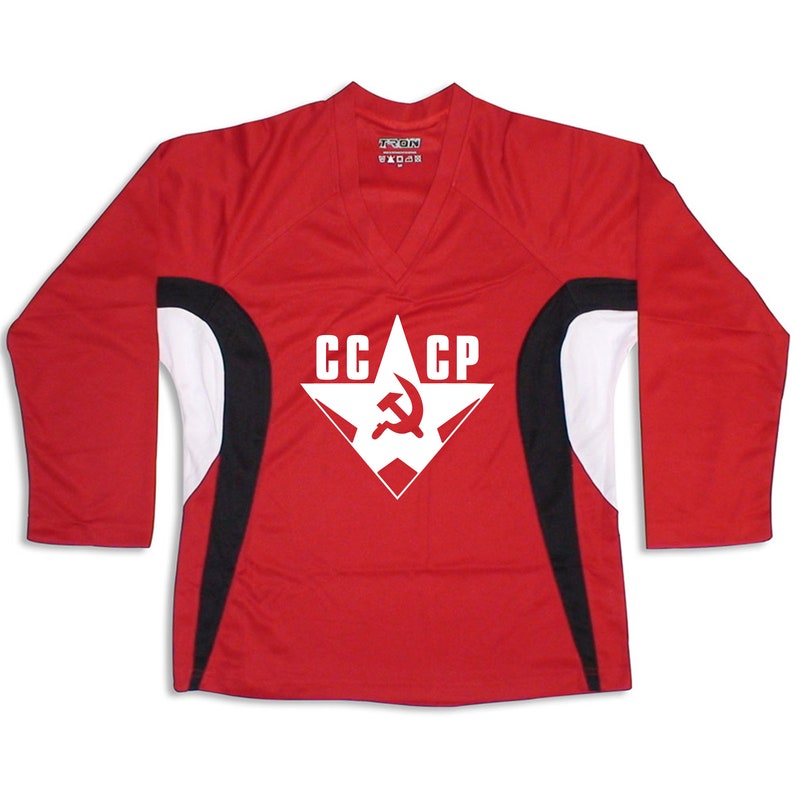 Puede incluir: Camiseta roja de manga larga con detalles en blanco y negro. La camiseta presenta una estrella blanca con un martillo y una hoz rojos en su interior y el texto "CCCP" encima.