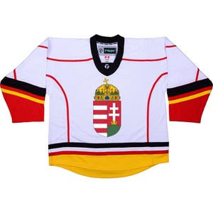 Könnte beinhalten: Weißes Hockeytrikot mit roten, schwarzen und gelben Streifen. Das Trikot zeigt das Wappen Ungarns, das eine Krone, ein Kreuz und einen Schild mit roten und weißen Streifen enthält.