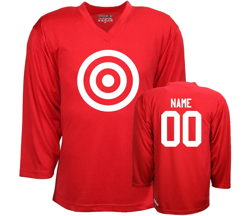 Puede incluir: Camiseta de hockey roja con un dise&ntilde;o de diana blanca en la parte delantera y el texto "NAME 00" en la parte posterior.
