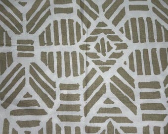 May include: Close-up of a white fabric with a repeating geometric pattern in shades of tan. The design features a series of thick, rectangular shapes and lines arranged in a symmetrical layout, creating a textured appearance. The fabric's pattern is suitable for various textile applications.