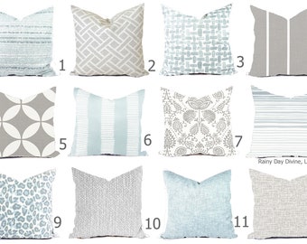 May include: Twelve different throw pillow designs featuring a variety of patterns in shades of gray and blue. The pillows are arranged in four rows of three.