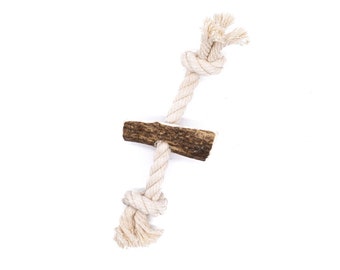 May include: A natural antler dog chew toy with a white cotton rope tied around it. The rope is knotted at both ends.
