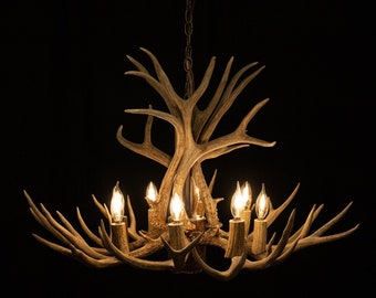 May include: A rustic chandelier made from antlers with eight light bulbs. The chandelier is hanging from a chain and has a natural brown color.