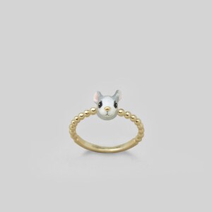 May include: A gold ring with a beaded band and a small, gray enamel mouse head charm.