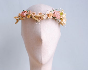 May include: A floral crown with peach, cream, and white flowers. The crown is made of silk flowers and is perfect for a wedding or other special occasion.