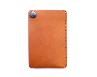 May include: A brown leather wallet with a snap closure and stitched edges.