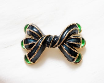 NINA RICCI – Brooch twisted triple bow gilded metal and night blue enamel encrusted with green glass cabochons