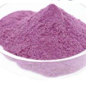 May include: A close-up of a bowl filled with a vibrant purple powder. The powder is smooth and fine, with a slightly grainy texture.
