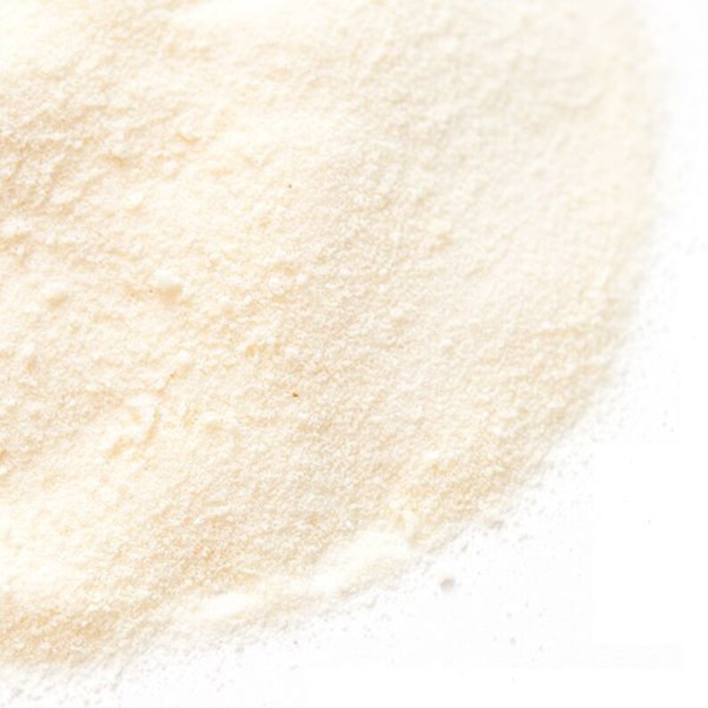 May include: A close-up of a pile of white powder. The powder is fine and smooth, and it has a slightly grainy texture.