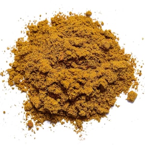 May include: A close-up of a pile of ground turmeric spice. The turmeric is a bright yellow-orange color and has a fine, powdery texture.