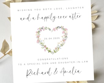 May include: A white card with a floral heart design and the text "Wishing you both love, laughter and a happily ever after" with the date "25.04.2025" and the text "Congratulations to a special son and daughter-in-law Richard & Amelia".