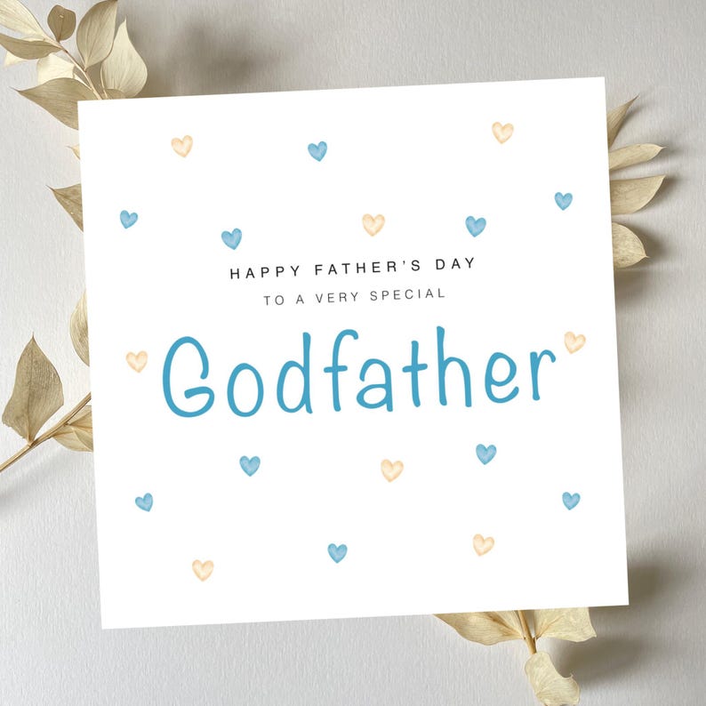May include: White card with blue and yellow hearts scattered across the surface. The card reads "Happy Father's Day to a very special Godfather".