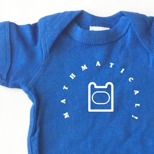 May include: A blue baby onesie with white text that reads "Mathematical" in a circle around a white outline of a bear head.