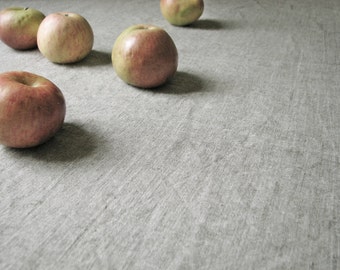Op de afbeelding: Vijf rode appels op een grijs, getextureerd oppervlak. De appels zijn in een halve cirkel gerangschikt.