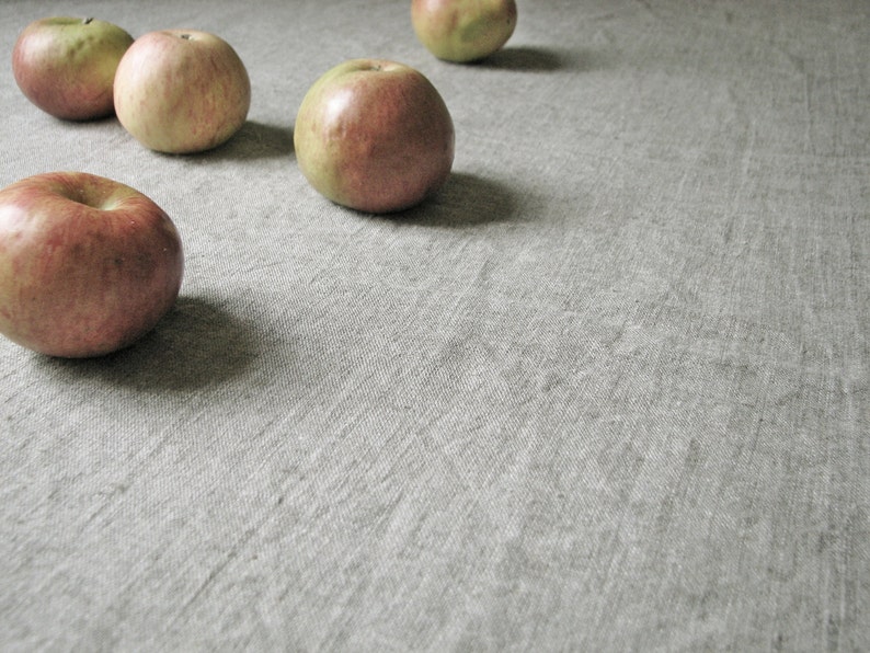 May include: Five red apples on a gray textured surface. The apples are arranged in a semi-circle.