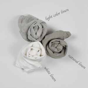 May include: Three rolls of linen fabric in different shades of gray. The rolls are labeled "light color linen", "natural linen", and "white linen".