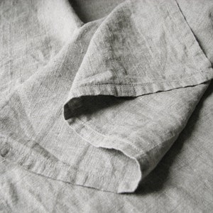 May include: A close-up of a gray linen fabric, showing the texture and folds of the material.