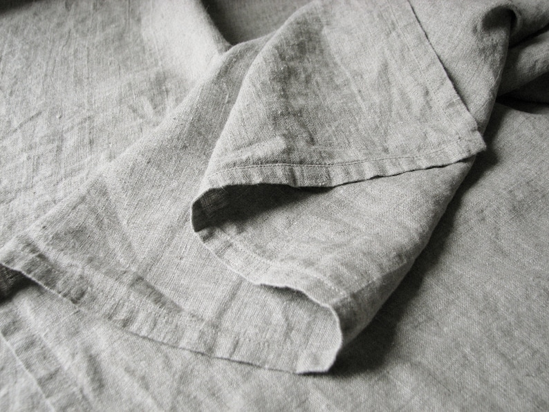 May include: A close-up of a gray linen fabric, showing the texture and folds of the material.