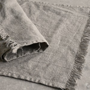 May include: A gray linen table runner with frayed edges.
