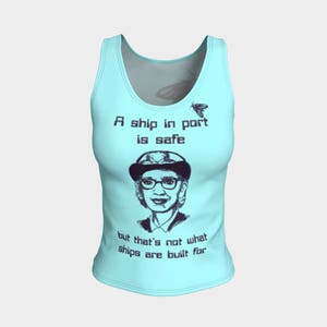 May include: A light blue tank top with a quote about ships and a black and white illustration of a woman wearing a hat and glasses. The quote reads "A ship in port is safe but that's not what ships are built for."