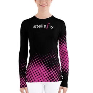 May include: Black long-sleeve shirt with a pink and black polka dot pattern. The shirt has the text "stellafly" in white on the front.