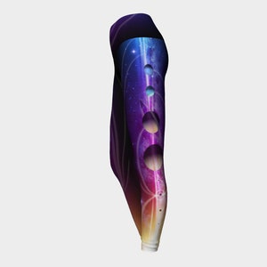 May include: Purple, blue, and orange galaxy print leggings with cutouts on the side. The leggings have a swirling galaxy design with planets and stars.