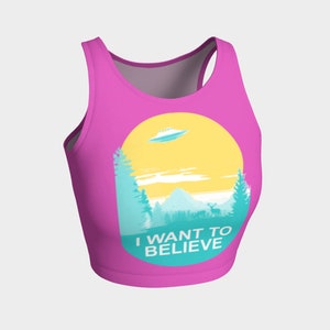 May include: Pink crop top with a graphic of a UFO over a mountain range with the text "I WANT TO BELIEVE" in a circle.
